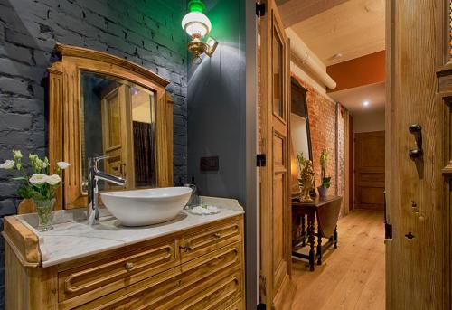 a bathroom with a bowl sink and a stone wall at B&B Royal Swans in Bruges
