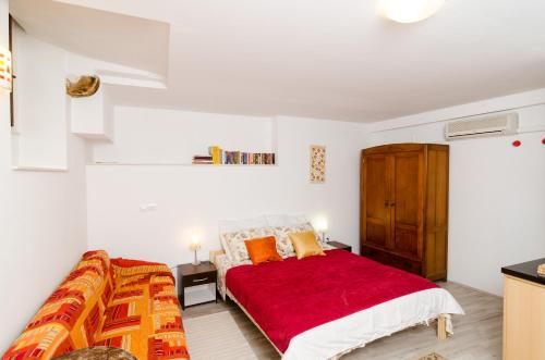 a bedroom with a red bed with a red blanket at Apartment Ronchi in Dubrovnik