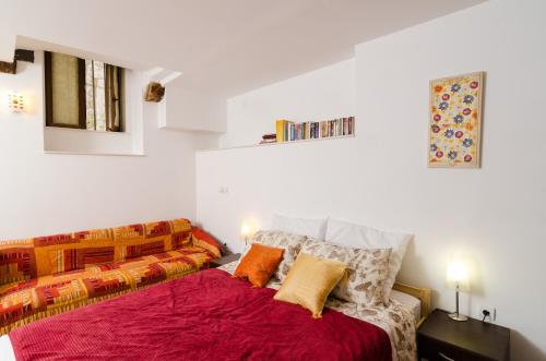 a bedroom with a bed with red sheets and orange pillows at Apartment Ronchi in Dubrovnik