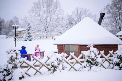 two people sitting on a fence in the snow at Tindioru Holiday House in Rõuge