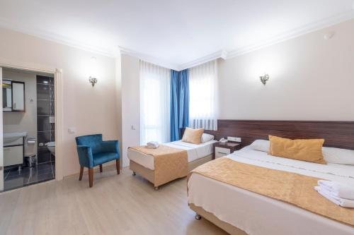 Pokój hotelowy z 2 łóżkami i niebieskim krzesłem w obiekcie Theluna City Hotel w mieście Antalya