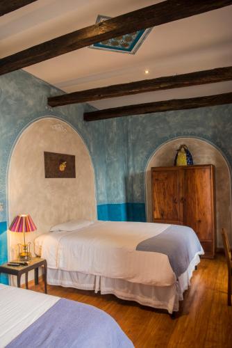 two beds in a room with blue walls at La Casa de Manuel Hotel-Boutique in Loja