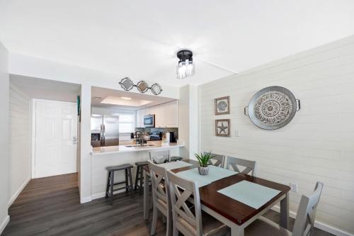 a dining room and kitchen with a table and chairs at Sunswept 607 condo in Orange Beach