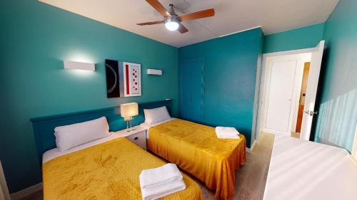 two beds in a room with blue walls at Apartamentos Eldorado in Lloret de Mar