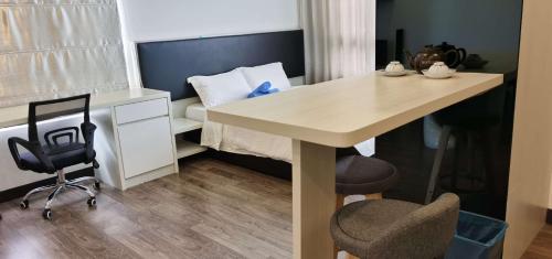加影Landmark Residence 2 Service Apartment 5min to MRT 20min to KL的一间有桌子、椅子和床的房间