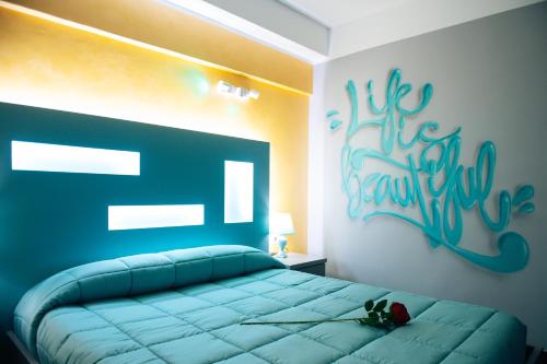 a bedroom with a blue bed with a sign on the wall at Dream B&B Roma in Rome