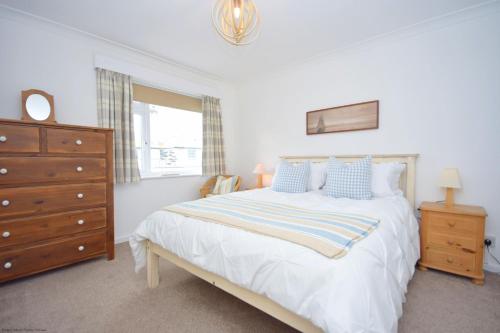 a bedroom with a bed with a dresser and a window at The Lookout - Bognor Regis in Bognor Regis