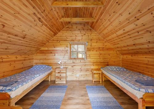 a log cabin with two beds in the attic at Ratsu Turismitalu in Jõgela