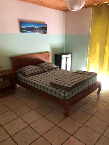 ein Schlafzimmer mit einem Bett in einem Zimmer in der Unterkunft Les Pruniers in Cilaos