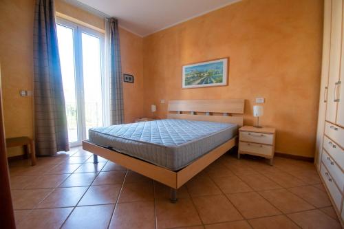 a bedroom with a bed and a large window at Lato soleggiato @Gardazzurro in Padenghe sul Garda