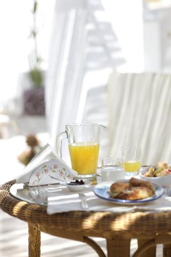 a table with a plate of food and a glass of orange juice at Relais Corte Palmieri & Il Chiostro - Residenza d'epoca in Gallipoli