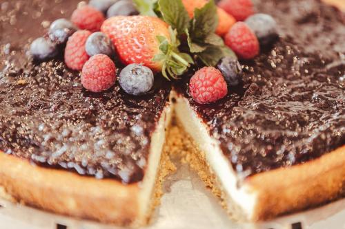 a chocolate cake with berries on top of it at Hotel Lis in Asti