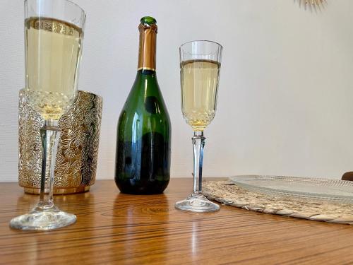 Una botella de vino y dos copas en una mesa. en Joli appartement au coeur de ville, en Château-Thierry