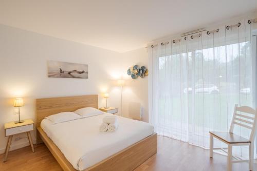 1 dormitorio con cama y ventana grande en AL LOAR AR MOR - A proximité de la Plage Pen Guen en Saint-Cast-le-Guildo