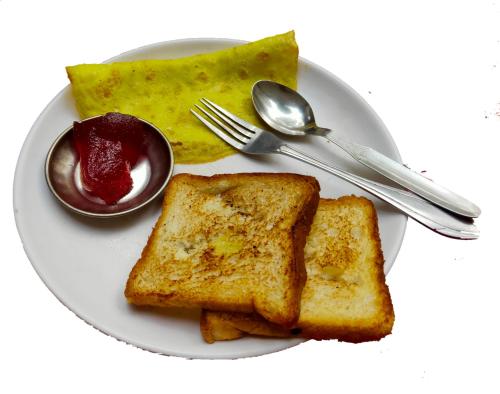 a white plate with toast and jelly on it at Lumbini Garden Lodge in Lumbini