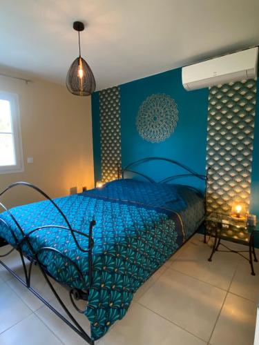 a bedroom with a bed with a blue wall at Gite ARCADIA in Saint-Ambroix