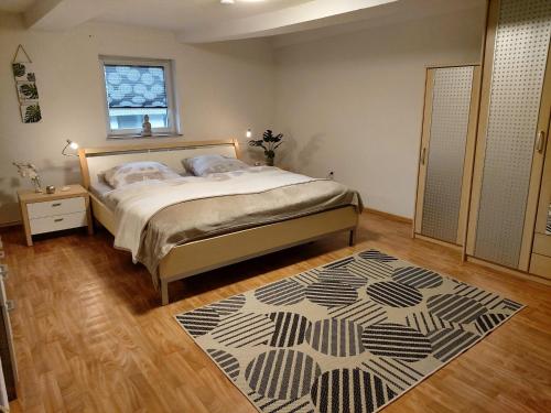 a bedroom with a bed and a rug on a wooden floor at Fewo Wolf in Einbeck