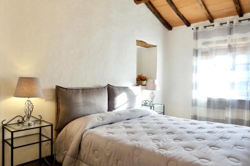 um quarto com uma cama grande e uma janela em Casa della Fonte - Self check-in em San Quirico dʼOrcia
