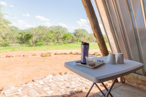 a table in a room with a view of a field at Tana Safaris Bush Camp in Otjiwarongo
