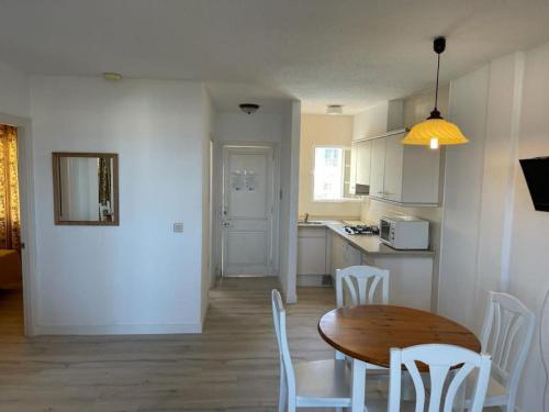 een keuken en eetkamer met een tafel en stoelen bij Apartamento CastellSol 102 in Arenal d'en Castell