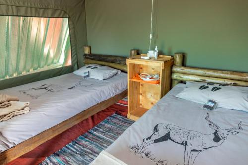 En eller flere senger på et rom på Tana Safaris Bush Camp