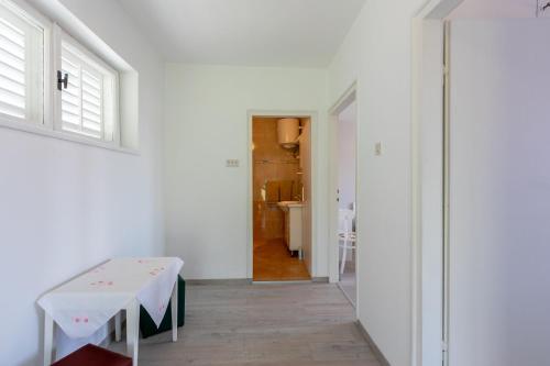 ein weißes Zimmer mit einem Tisch und einem Flur in der Unterkunft House Milenka in Banjol