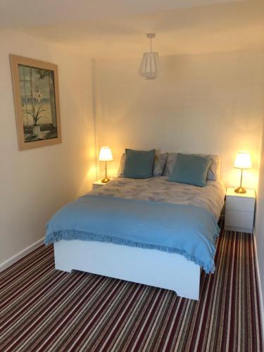 a bedroom with a large bed with two lamps at Old Picture House in Seaton