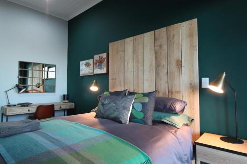 a bedroom with a bed with a wooden headboard at Lekkerberg in Riebeek-Kasteel