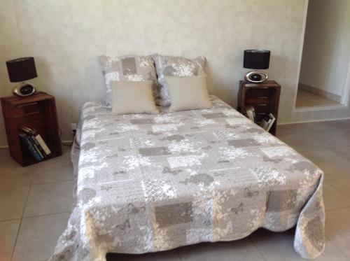 une chambre avec un grand lit avec deux tables de nuit dans l'établissement Gite d'Isa, à Saint-Remèze