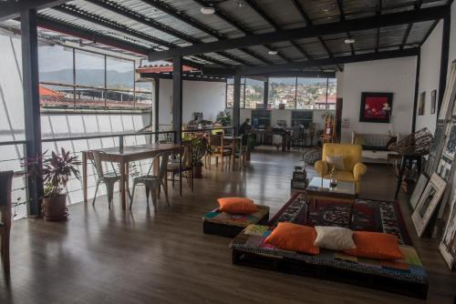 una stanza con tavoli e sedie e una stanza con finestre di La Casa de Manuel Hotel-Boutique a Loja