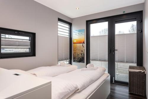 two beds in a room with large windows at Houseboat 'Elysium' met eigen aanlegsteiger Sneek - Offingawier in Offingawier