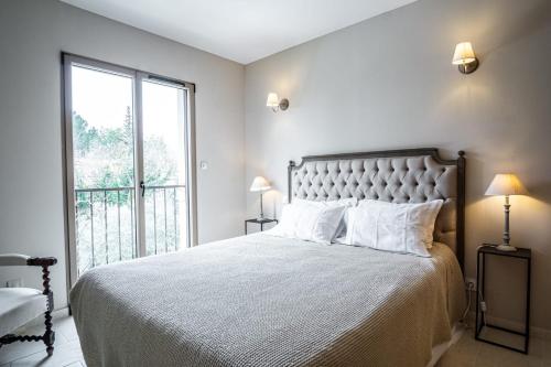 a bedroom with a large bed and a large window at La Maison de l'Yle - Villa avec piscine in L'Isle-sur-la-Sorgue