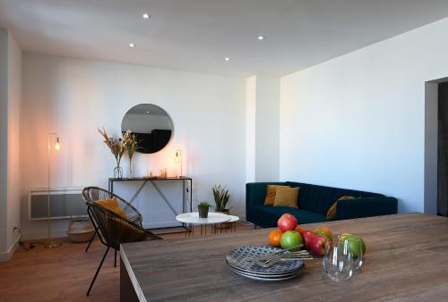 una sala de estar con una mesa con fruta. en Sognu di Matteu - Bel appartement entièrement climatisé - vue mer, vieux port Bastia en Bastia