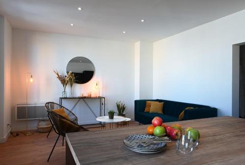 een woonkamer met een tafel met fruit erop bij Sognu di Matteu - Bel appartement entièrement climatisé - vue mer, vieux port Bastia in Bastia