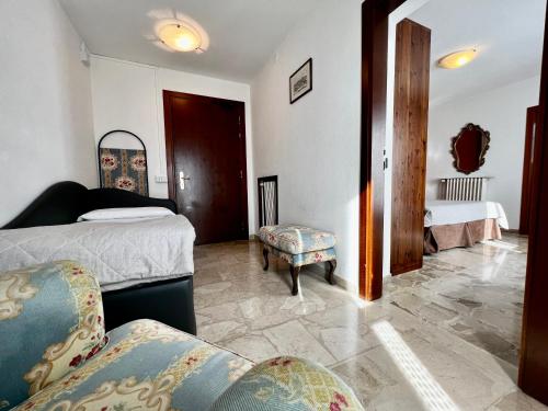 a bedroom with two beds and a chair and a couch at Aurora in Castione della Presolana