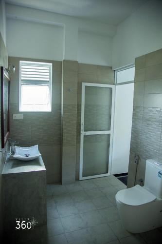 a bathroom with a toilet and a sink and a shower at Villa 360 in Talpe