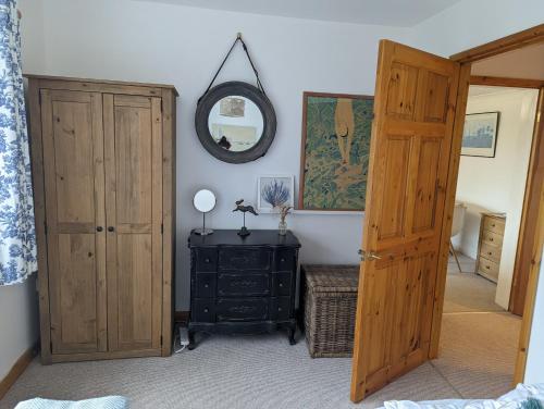 a bedroom with a wooden door and a mirror at Cosy 2-Bed Property in Ashburton Dartmoor in Newton Abbot