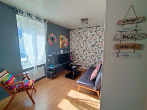 a living room with a couch and a chair at L'éléphant Blanc de ConcarnOLoc in Concarneau