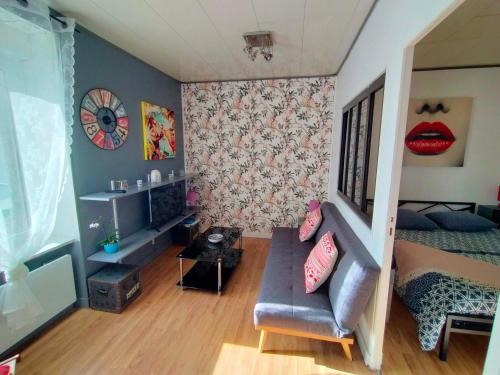 a living room with a couch and a bedroom at L'éléphant Blanc de ConcarnOLoc in Concarneau