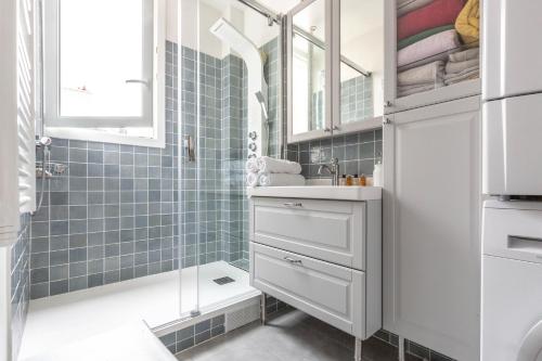 une salle de bain avec un lavabo et une douche dans l'établissement Veeve - The Timekeeper, à Paris