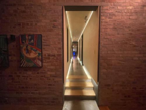 a long hallway with a brick wall and a staircase at Lekkerberg in Riebeek-Kasteel