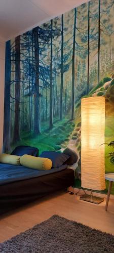 a bedroom with a mural of a forest at Good Life Homestay in Ahmovaara