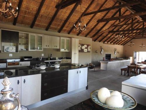 a large kitchen with white cabinets and a table at Balule Bushveld Safari Lodge in Phalaborwa