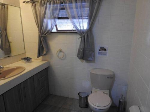 a bathroom with a toilet and a sink and a window at Balule Bushveld Safari Lodge in Phalaborwa