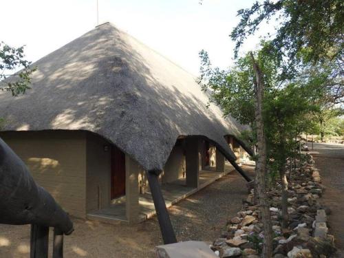 a house with a thatched roof on the side of it at Balule Bushveld Safari Lodge in Phalaborwa