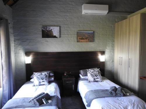 a bedroom with two beds with towels on them at Balule Bushveld Safari Lodge in Phalaborwa