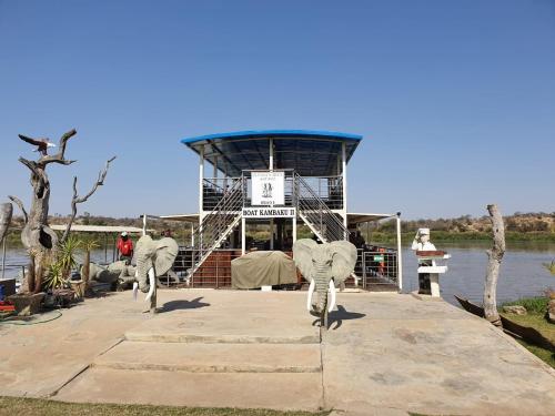two elephants standing on a dock with a ferry at Balule Bushveld Safari Lodge in Phalaborwa