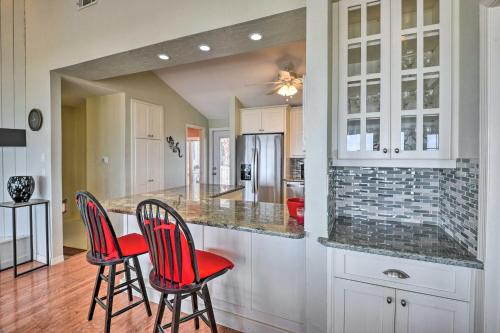 a kitchen with two red chairs and a counter at Sunny Home with Decks and Views, Steps to Beach! in Flagler Beach