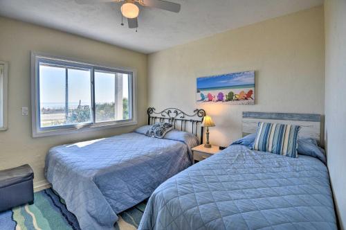 a bedroom with two beds and a window at Sunny Florida Home with Decks and View, Steps to Beach in Flagler Beach