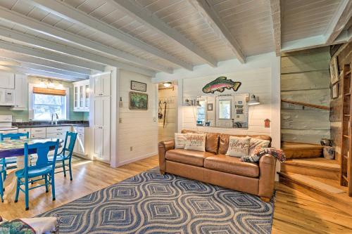 a living room with a couch and a table at Riverfront Home with Fire Pit and Deck in Lansing in Lansing